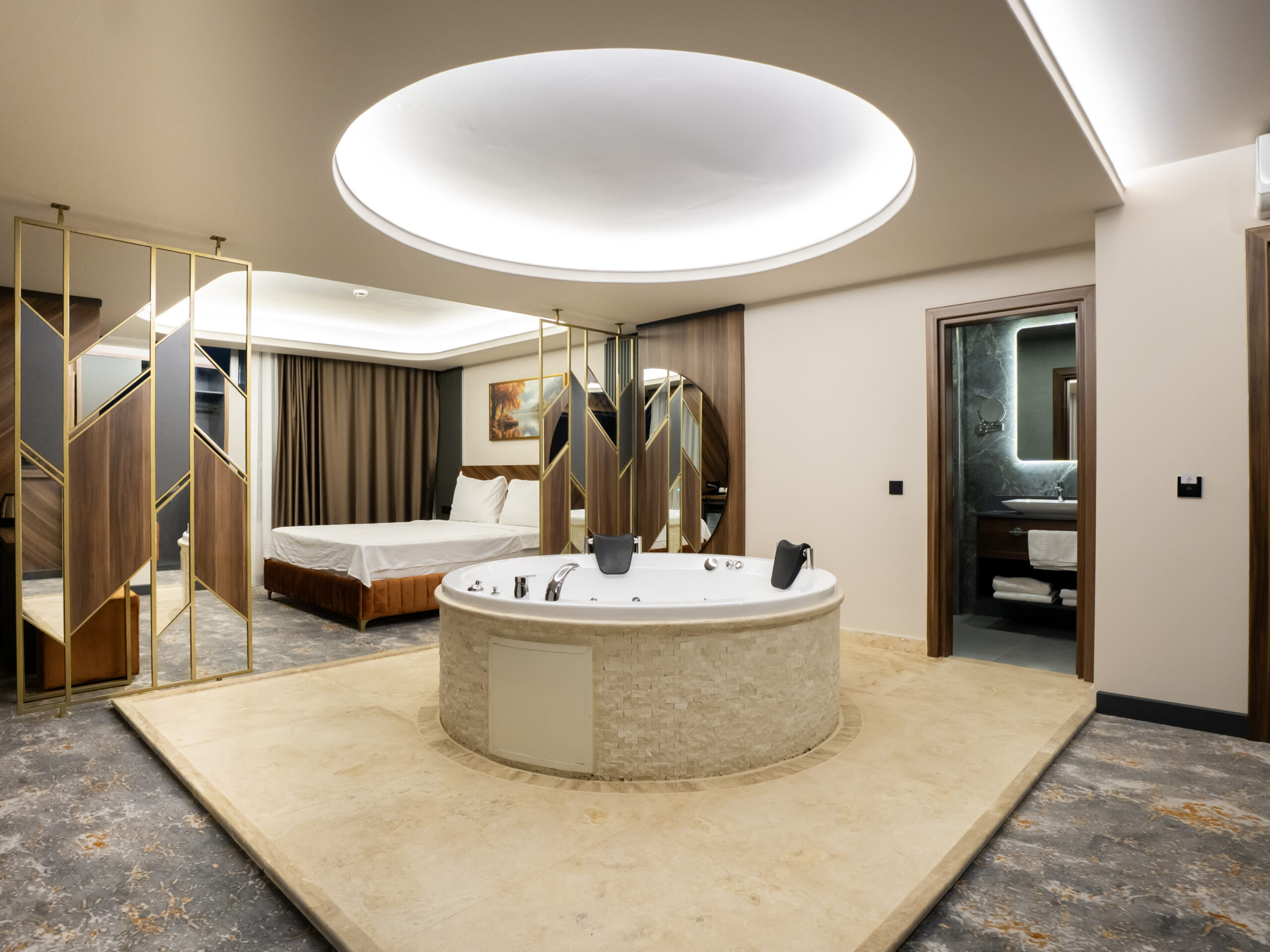 Misafir suit odası — yatak, jakuzi ve banyo girişi