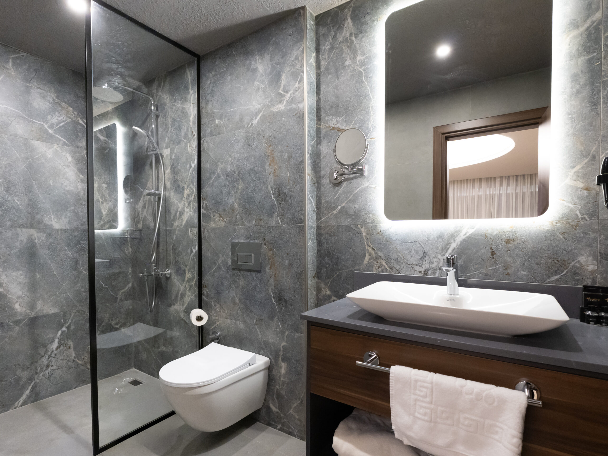 Premium banyo donanımı — mermer kaplama ve aydınlatmalı ayna